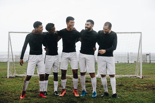 Group of soccer players standing near the goalpost