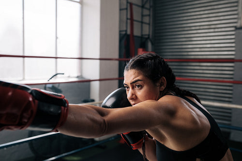Female boxer training inside a boxing ring