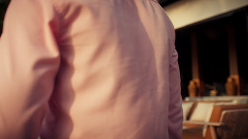 Waiter carrying cocktails to couple at tropical beach resort