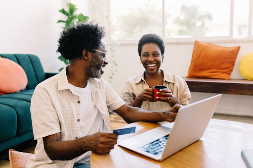 Couple shopping online with a credit card in the comfort of their home