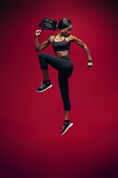 Healthy african woman jumping and exercising