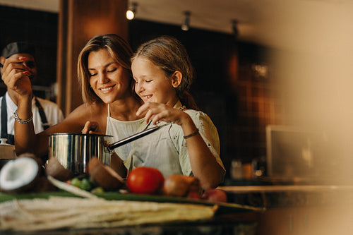 Mother and daughter cooking together in a warm and cozy kitchen setting