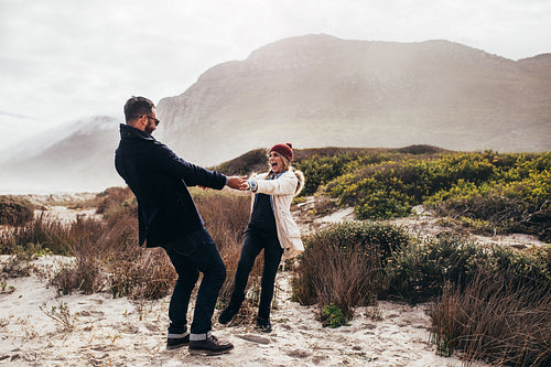 Loving couple having fun at the beach on winter day