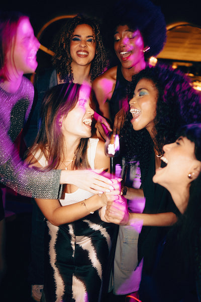 Group of friends celebrating together during a lively night out with smiles