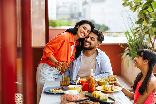 Latino family enjoying a joyful outdoor meal on a bright sunny day