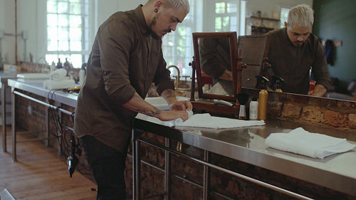 Barber rolling a soaked towel
