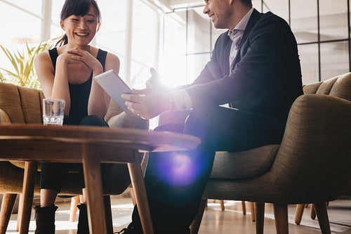 Corporate colleagues discussing business ideas on digital tablet