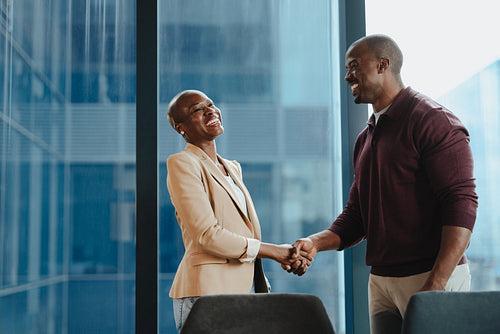 Successful business people shaking hands to a promotion in a professional office