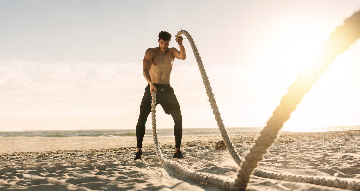 Man doing workout using battling ropes at the beach – Jacob Lund ...