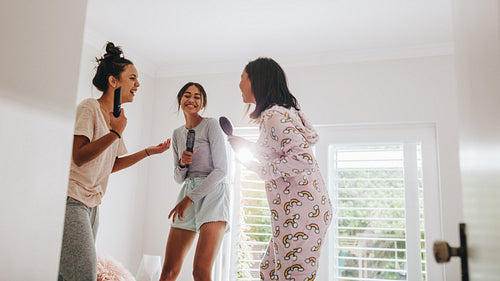Girls having fun singing karaoke at a sleepover