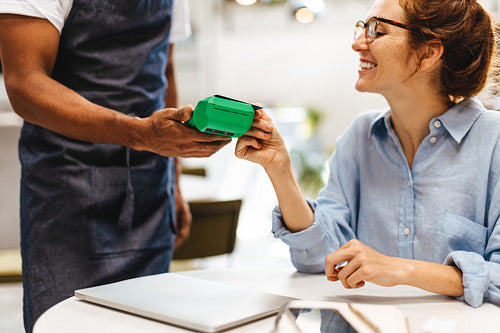 Happy woman paying with a credit card in a restaurant