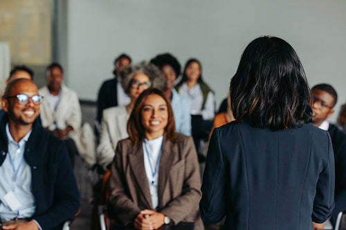 Businesswoman presenting at a meeting with smiling colleagues and coworkers