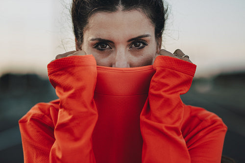 Sportswoman covering her face with tracksuit