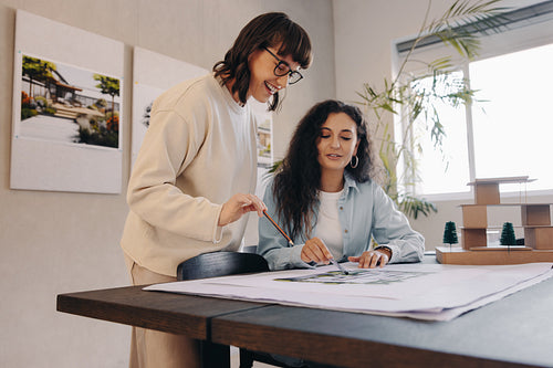 Collaborative planning session involving project drawings and creative brainstorming