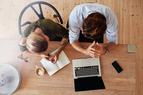 Two people working together on laptop at cafe