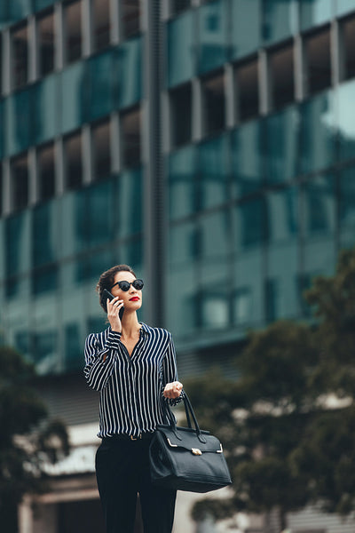 Asian woman walking on the street with mobile phone