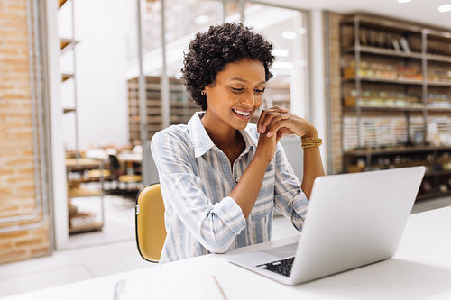 Happy young businesswoman having a video call in a warehouse
