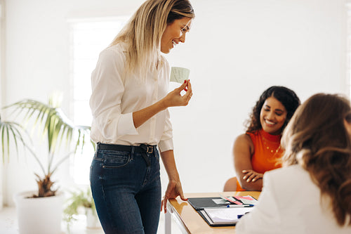 Happy businesswoman brainstorming with her team in a boardroom