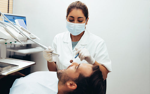 Dentist inspecting teeth of male patient