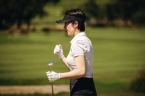Female golf player celebrating a successful putt with a fist pump