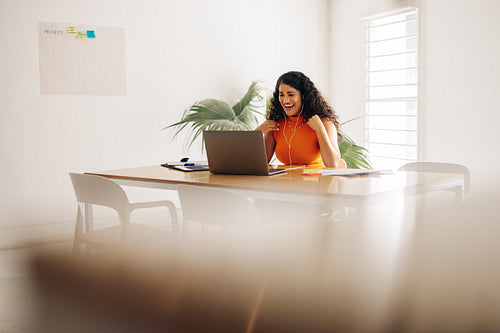 Excited businesswoman having a video call in a boardroom