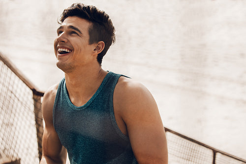 Muscular man taking a break after workout and laughing