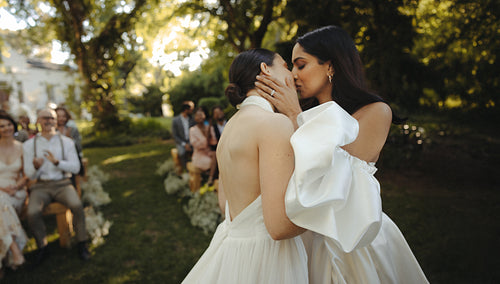 Romantic outdoor wedding ceremony with newlyweds sharing a heartfelt kiss