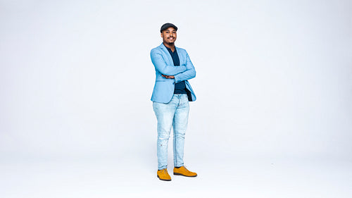 Businessman in cap standing with his arms crossed