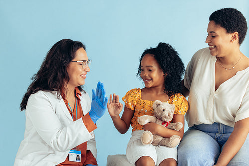 Doctor giving young patient a high five