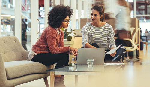 Two businesswomen discussing work in office