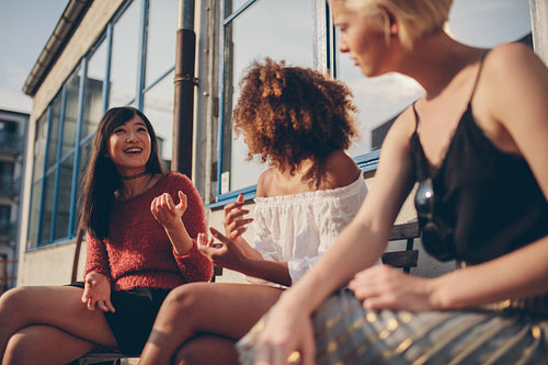 Female friends sitting outdoors and talking