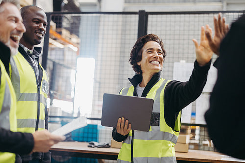 Warehouse workers celebrating their success during a meeting