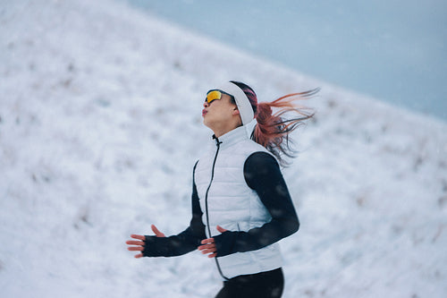 Resilience marks the running woman crossing mountain snow during winter fitness