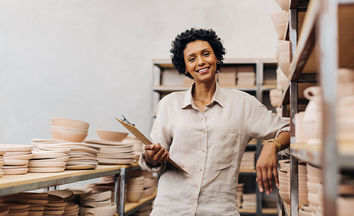 Successful ceramic shop owner smiling at the camera in her store