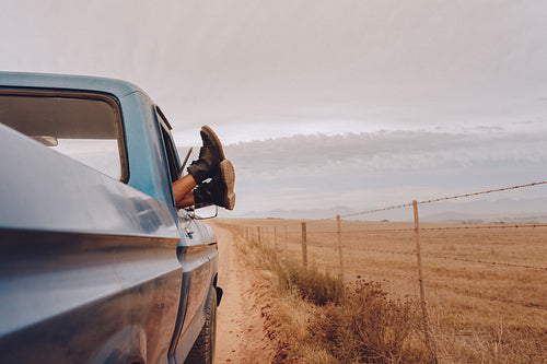 Woman hanging her legs out of car window