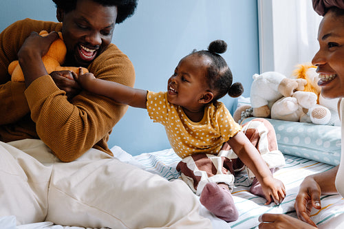 Family playtime with baby in cozy bedroom