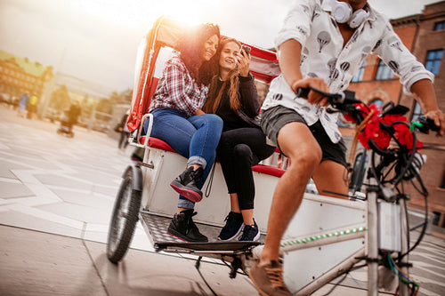 Teenage girls taking selfie on tricycle ride