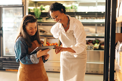 Convenience store workers using a digital tablet together