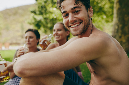 Close up of a man on holiday sitting with two female friends