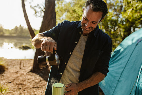 Camper having coffee at a campsite
