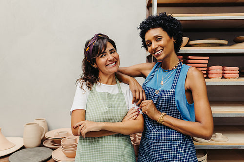 Successful craftswomen smiling at the camera in their workshop