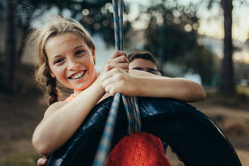 Kids playing in park on a tire swing