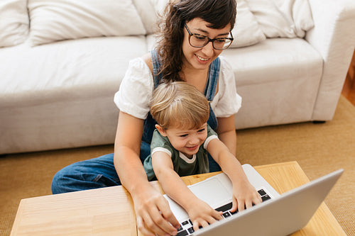 Smiling woman and son with laptop