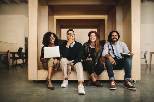 Office mates relaxing during work sitting together in a wooden enclosure