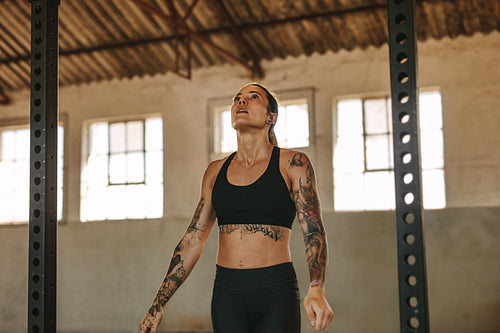 Tattooed woman exercising in an empty warehouse