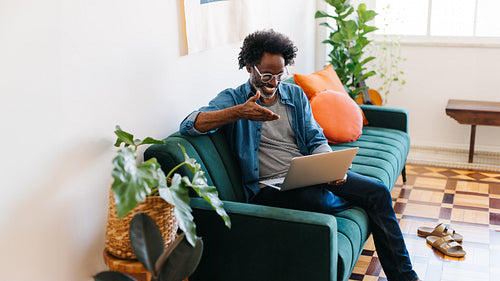 Mature man working from home with a laptop, having a video call with with his team