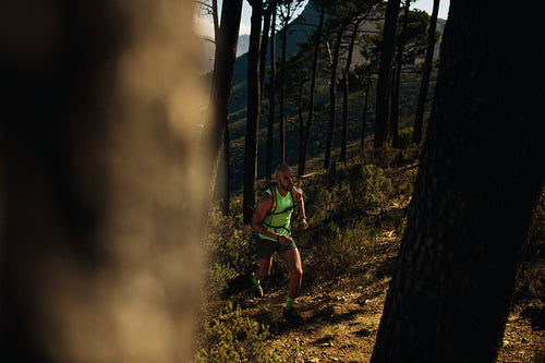 Man running over rocky trail on the hill