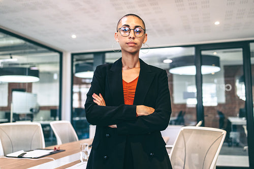 Young businesswoman standing with her arms crossed in a boardroom