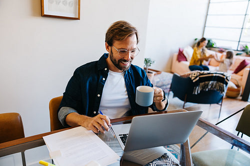 Family man working at home with mug and laptop