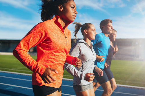 Woman running with her team on racetrack